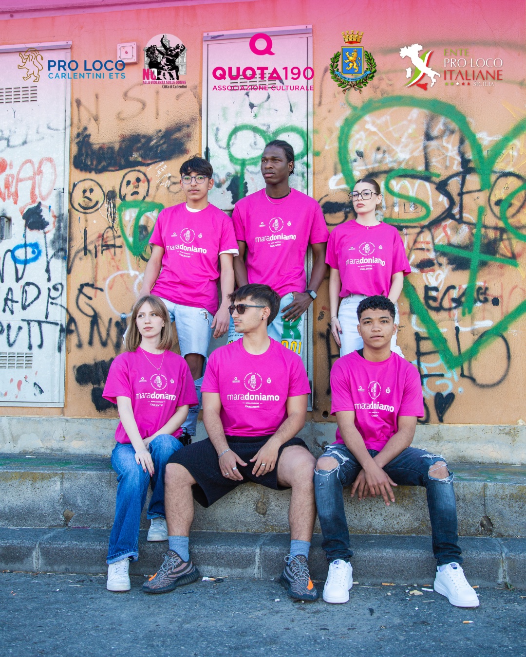 I ragazzi dello shooting con le magliette fucsia al muretto